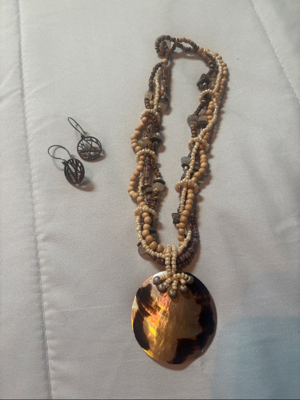 boho-style beaded statement necklace featuring a large abalone shell pendant